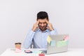 Migraine of stressful job. Depressed man employee sitting in office, clasping head temples, suffering headache Royalty Free Stock Photo