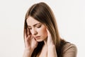 Migraine is a strong headache of girl on white background. Overstressed young woman touches her head because of