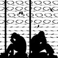Migrant refugees behind barbed wire, silhouette of two sad men s