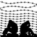 Migrant refugees behind barbed wire, silhouette of two sad men s