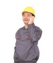 Migrant worker wearing yellow hard hat in front of white background is calling home Royalty Free Stock Photo