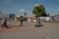 Migrants from the southern republics walk along the station square with their luggage to a bus stop on a sunny summer day