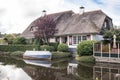 Thatched cottage beside a canal river with garden and boat