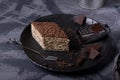 Mikado cake with caramel and chocolate buttercream on the black ceramic plate