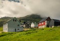 Mikladalur, Faroe Islands - 07/07/2019Village Mikladalur on a sunny summer day, mountain in the background covered in clouds,