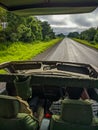 Mikumi, Tanzania - December 6, 2019: sitting on top of a safari jeep to see the savannah in africa. Vertical