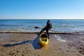 Mil palmeras, Spain, January 11, 2020: A sportsman and fisherman wearing a jacket stands in the water near a kayak boat.
