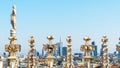 Milan cityscape through sculptures on the roof of Duomo cathedral.