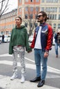 Couple poses for photographers with silver trousers and western boots before Emporio Armani fashion show,