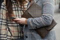 Man with Louis Vuitton bag looking at smartphone before fashion Albino Teodoro show, Milan Fashion Week