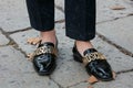 Man poses for photographers with black shiny Moschino shoes before Gucci fashion show, Milan Fashion Week Day
