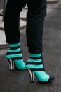 MILAN - FEBRUARY 22: Woman with black and green striped high heel shoes before Fendi fashion show, Milan Fashion Week street style