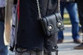 Woman with black leather bag with silver lion heads decorations before Giorgio Armani fashion show, Milan