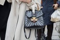 Woman with black reptile leather Gucci bag with golden jewel bee with gems before Max Mara fashion show,