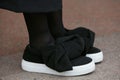 Woman with black shoes with fabric ribbon and white sole before Cristiano Burani fashion show, Milan Fashion