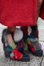 Woman with boots with colorful fur decoration and red coat before Max Mara fashion show, Milan Fashion Week