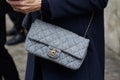 Woman with gray fabric Chanel bag with golden details before Max Mara fashion show, Milan Fashion Week street