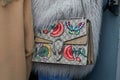 Woman with Gucci bag with butterfly and flowers decorations and gray, fur coat before fashion Albino Teodoro