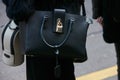 Woman with Patrizia Pepe black leather bag before Blumarine fashion show, Milan Fashion Week street style on Royalty Free Stock Photo