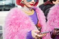 MILAN - FEBRUARY 21: Woman with pink fur coat and hair looking at smartphone before Gucci fashion show, Milan Fashion Week street