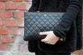Woman poses for photographers with black leather Chanel bag before Fendi fashion show, Milan Fashion Week Day