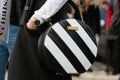 Woman poses for photographers with black and white Concept 15 bag before Gucci fashion show, Milan Fashion