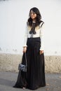 Woman poses for photographers with black and white dress and Hermes bag before Emilio Pucci fashion show,