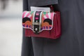 Woman poses for photographers with colorful leather bag before Costume National fashion show, Milan Fashion