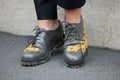 Woman poses for photographers with gray shoes with yellow embroidery before Etro and Iceberg fashion show,