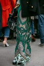 Woman poses for photographers with green intricate floral design before Etro and Iceberg fashion show, Milan