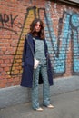 Woman poses for photographers with overalls with intricate clover design before Fendi fashion show, Milan