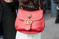 Woman poses for photographers with red Gucci bag with tiger head before Gucci fashion show, Milan Fashion