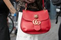 Woman poses for photographers with red Gucci bag with tiger head before Gucci fashion show, Milan Fashion