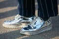 Woman poses for photographers with silver shoes before Emilio Pucci fashion show, Milan Fashion Week Day 2