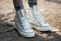 Woman poses for photographers with silver sneakers shoes before Emporio Armani fashion show, Milan Fashion