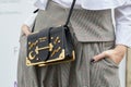 Woman with Prada black leather bag with stars and moon golden decorations before fashion Albino Teodoro show