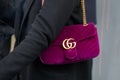 Woman with purple velvet Gucci bag with golden logo and chain before fashion Albino Teodoro show, Milan