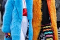 Women with blue and orange fur coats before Diesel Black Gold fashion show, Milan Fashion Week street style