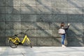 MILAN, ITALY - APRIL 2019 : Girl Takes a Picture on an Empty Wall near at bike