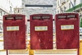 Old red metal mailboxes. City of Milan, Italy