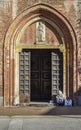 An elderly woman beggar who appears to be a Roma Gypsie begging in front of a church in Milan