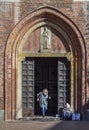 An elderly woman beggar who appears to be a Roma Gypsie begging in front of a church in Milan