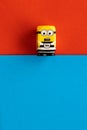Milan, Italy - August 11 2019: Minion toy in prisoner`s clothes with shocked expression on red blue paper background