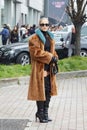 MILAN, ITALY - FEBRUARY 24, 2023: Caro Daur with brown fur jacket and black high heel boots before Gucci fashion show, Milan