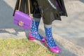 Model wears a pair of purple heel shoes and a purple shoulder bag