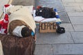 Milan, Italy February 2023: Poor homeless boy sleeping in the street in the sleeping bag with his dog