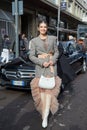 MILAN, ITALY - FEBRUARY 25, 2023: Woman with ancient pink tulle skirt and white leather Prada bag before Ermanno Scervino fashion