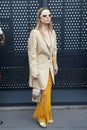 MILAN, ITALY - FEBRUARY 24, 2023: Woman with beige jacket, Gucci bag and orange net skirt before Gucci fashion show, Milan Fashion