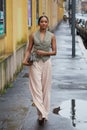 Woman with beige trousers and grey green bag before Tods fashion show, Milan Fashion Week