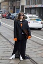 MILAN, ITALY - FEBRUARY 24, 2023: Woman with black jacket and orange shirt before Sportmax fashion show, Milan Fashion Week street